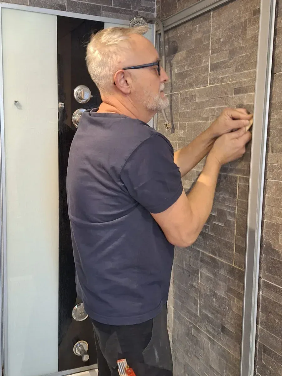Renzo Guggisberg bei Arbeiten an der Dusche