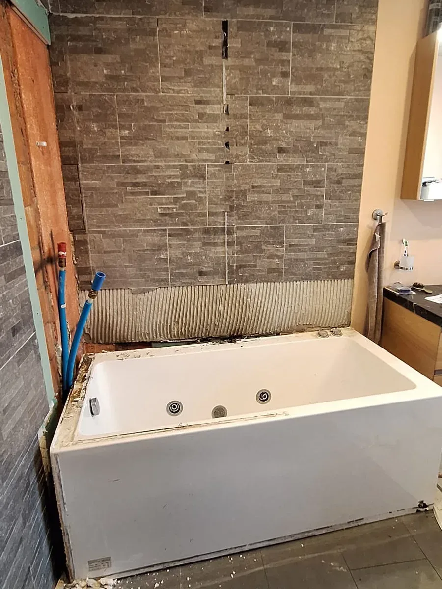 Badewanne und Steinwand während der Sanierung