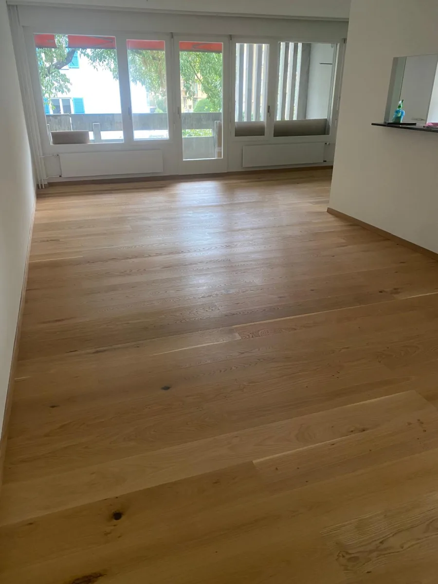 Heller Wohnraum mit Holzboden nach der Aufbereitung